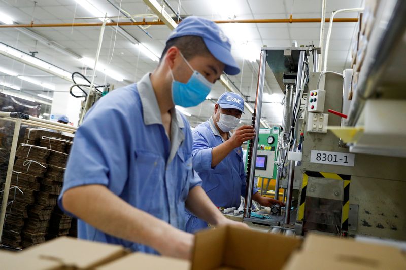 FILE PHOTO: Employees wearing masks work at a factory of