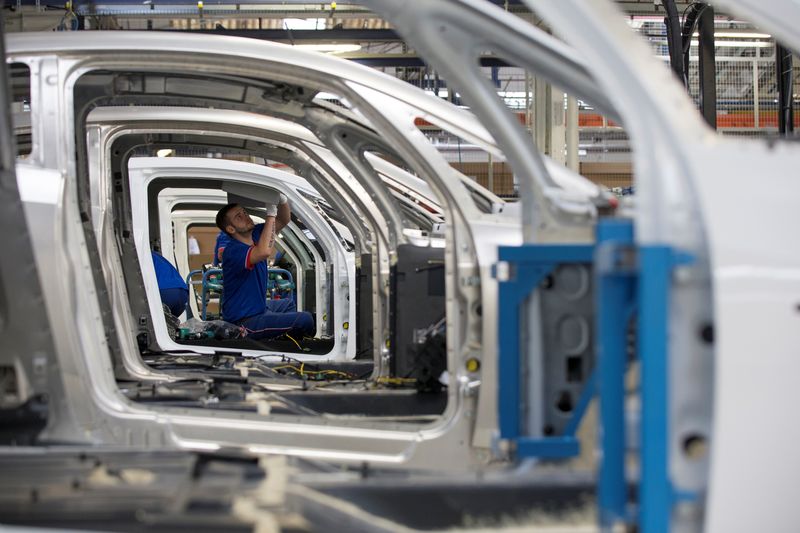 An employee works on the automobile assembly line of Bluecar