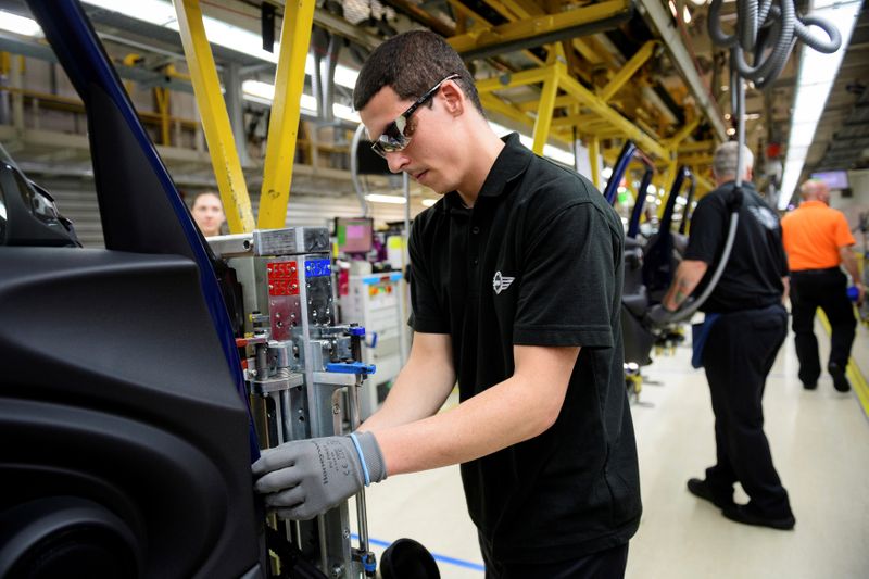 Workers assemble cars at the plant for the Mini range