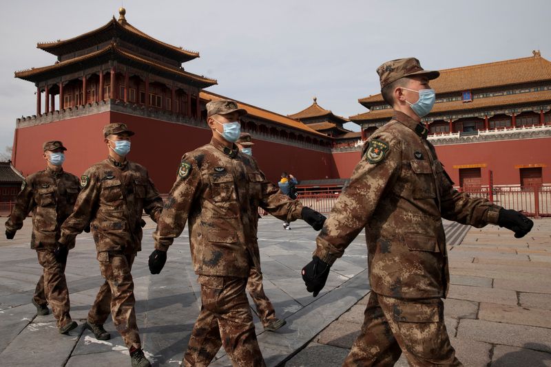 Paramilitary police officers walk in formation outside the Forbidden City