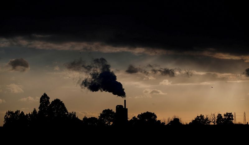 FILE PHOTO: Smoke rises above a factory at sunset in