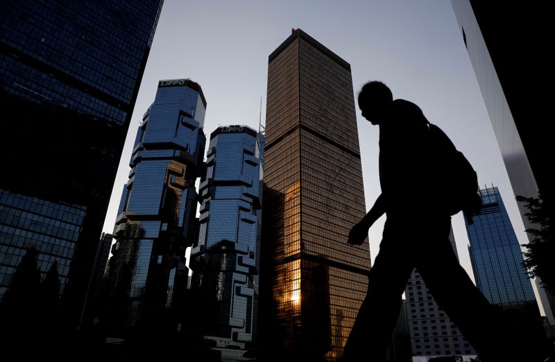 A man walks past buildings at a business district in