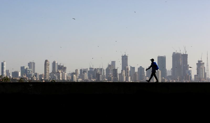 A man walks along a wall overlooking the central Mumbai’s
