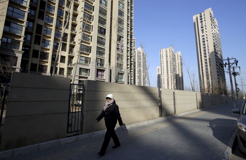 A woman walks past a residential compound in Beijing’s Tongzhou