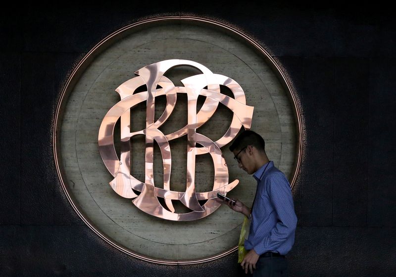 A worker walks pasts the logo of the Central Reserve