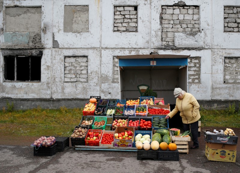 A woman sells fruit and vegetables in a street in