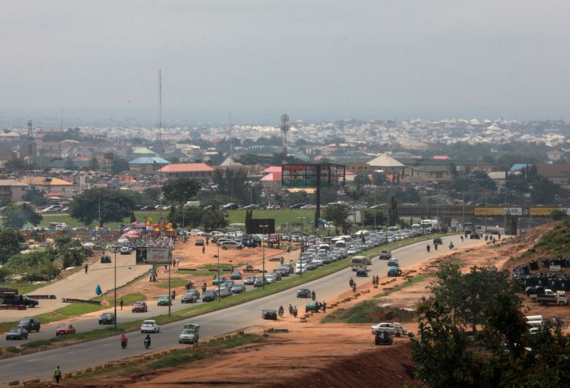 Cars drive along a street in Abuja