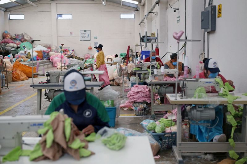 Women work in the manufacture of soft toys ahead of