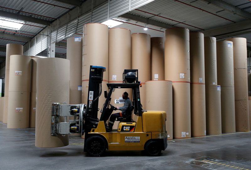 FILE PHOTO: An employee transports a giant reel of paper