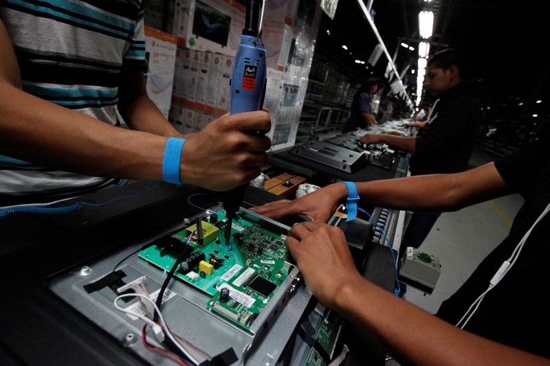 An employee works at an LED TV assembly line at