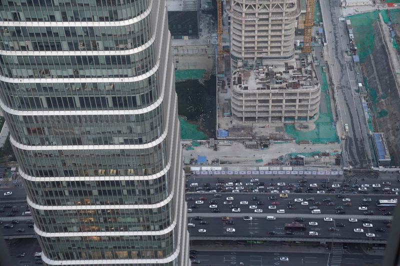 Cars drive past construction sites in Beijing’s central business area