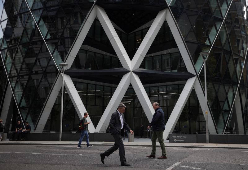 People walk through the City of London financial district in