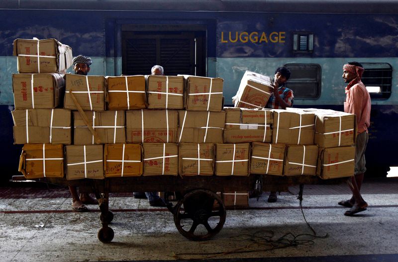 Porters prepare to load goods onto a train at a