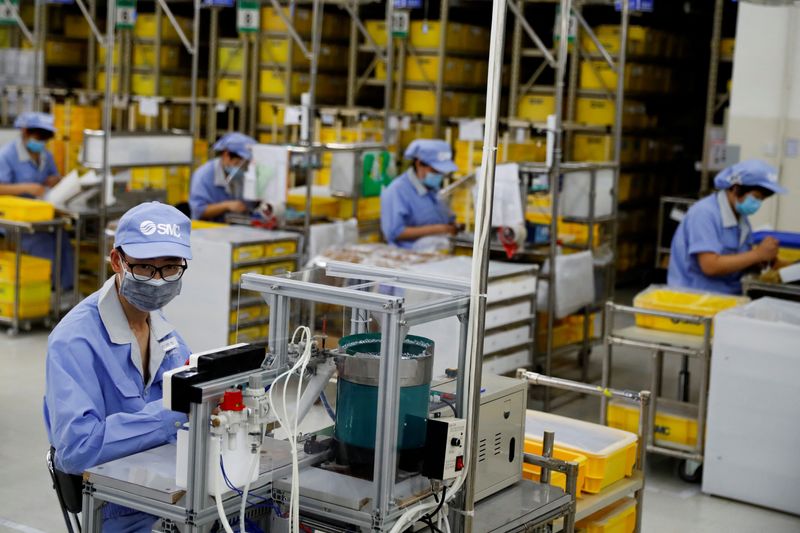 FILE PHOTO: Employees wearing face masks work at a factory