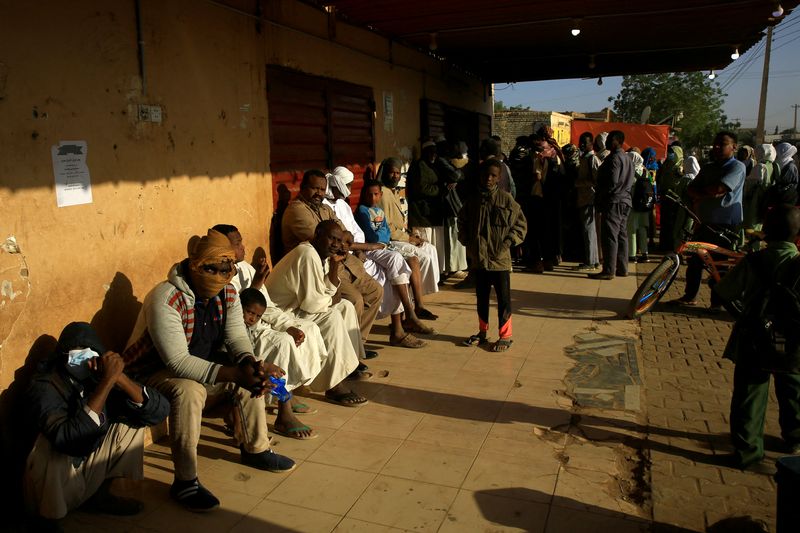 People gather outside a bakery to get bread in Khartoum