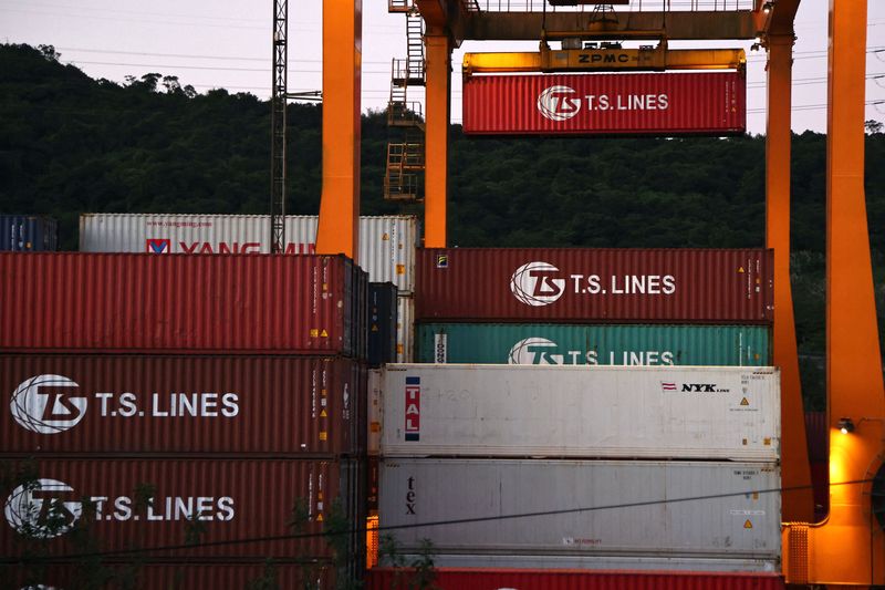 Cargo cranes are seen moving containers at a container yard