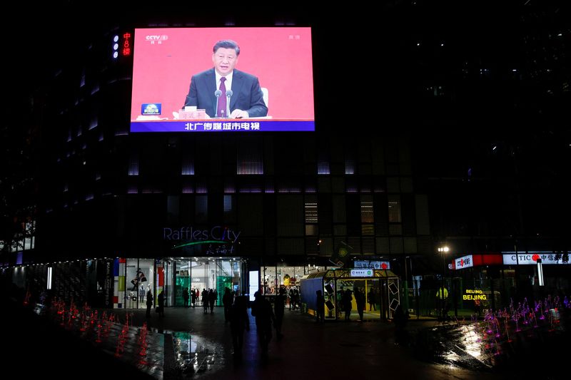 A giant screen shows news footage of Chinese President Xi