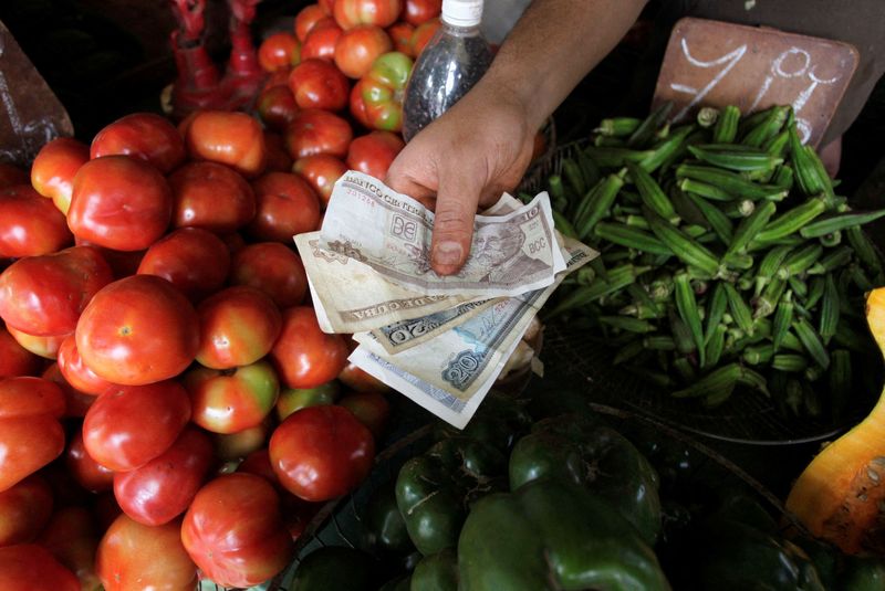 FILE PHOTO: A man shows Cuban Peso bills at a