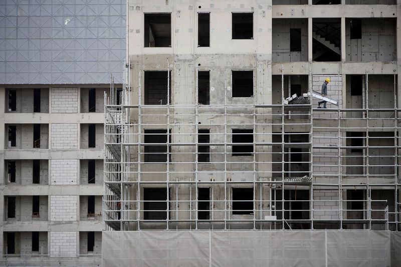 A worker walks on scaffolding at a construction site in