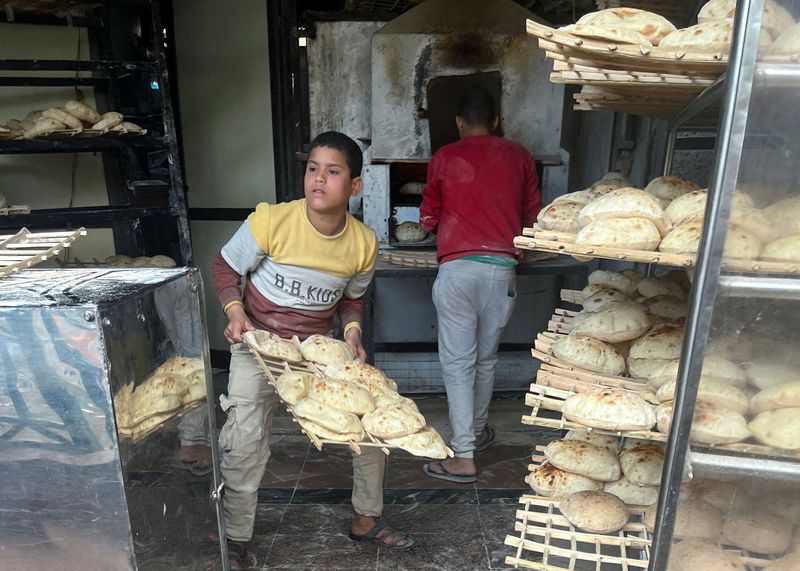 FILE PHOTO: Employees arrange bread for sale at a bakery