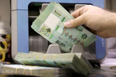 FILE PHOTO: A man counts Lebanese pound banknotes at a