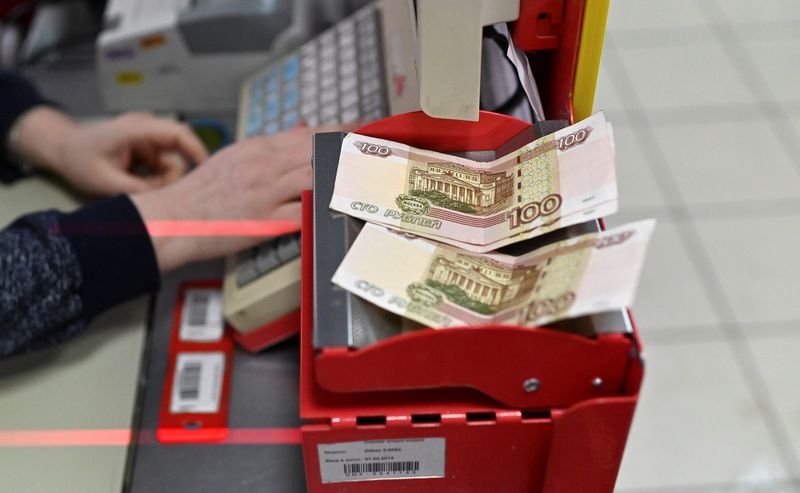 Russian 100-rouble banknotes are placed on a cashier’s desk at