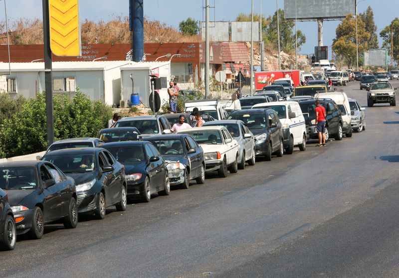 FILE PHOTO: Cars stand in line near a gas station
