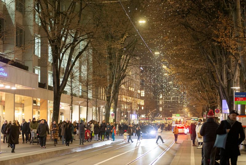 People walk under the Christmas illuminations on the Bahnhofstrasse shopping