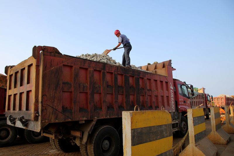 A man works on transporting iron ore on a truck