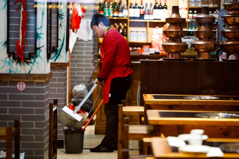 A waiter cleans the floor of a restaurant after closing