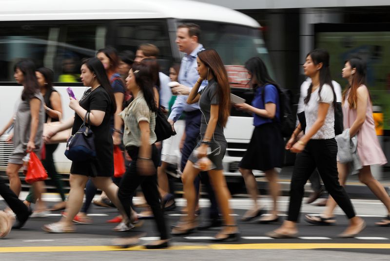 Office workers cross a street in Singapore’s central business district