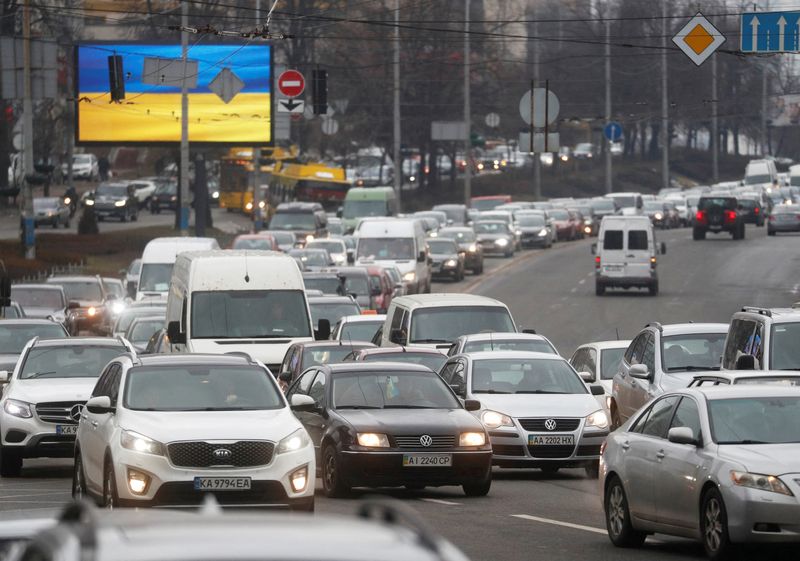 Cars drive towards the exit of the city after Russian