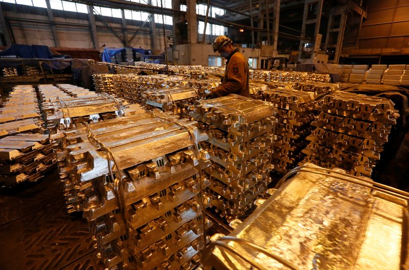 A worker stores aluminium ingots at the foundry shop of