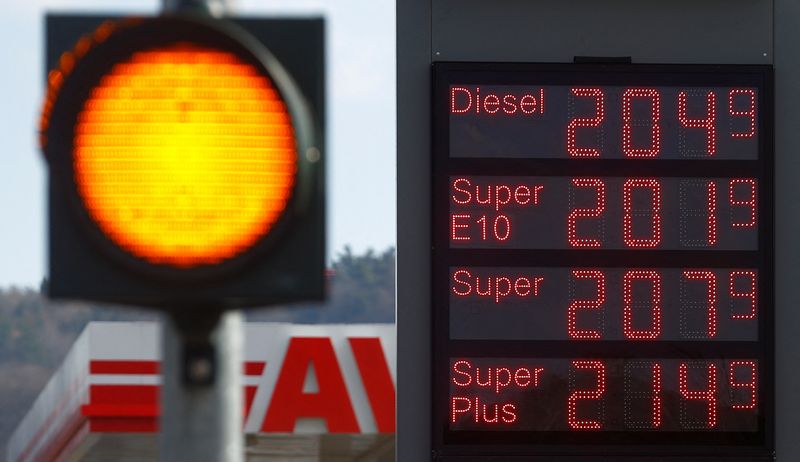 A display shows fuel prices per litre at a gas