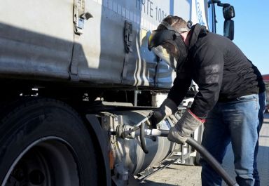 A truck driver stands at a LNG (Liquefied Natural Gas)