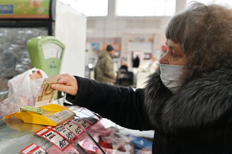 A customer hands over Russian rouble banknotes to a vendor