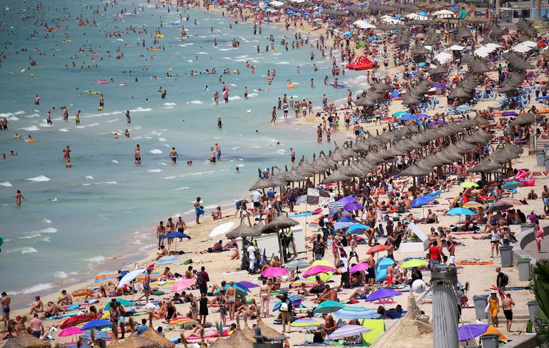 FILE PHOTO: Pre-pandemic tourists sunbathe in El Arenal beach in