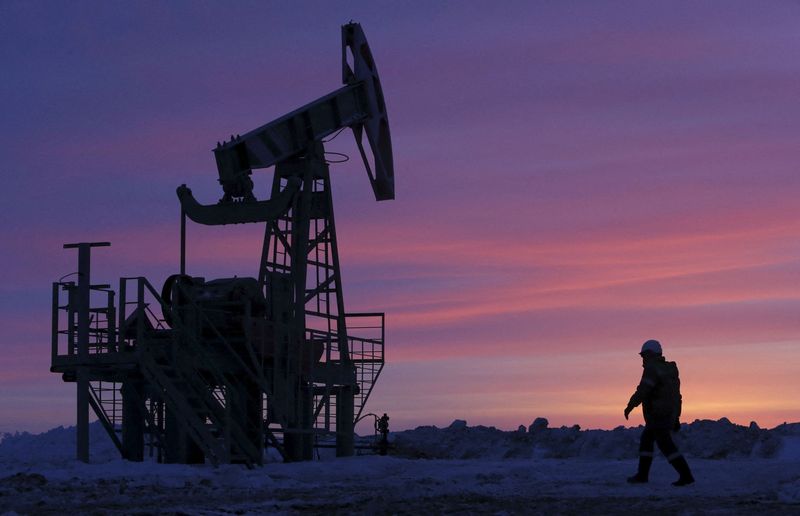 FILE PHOTO: A worker walking past a pump jack on