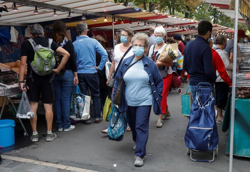 People wear protective masks at an open-air market, in Paris