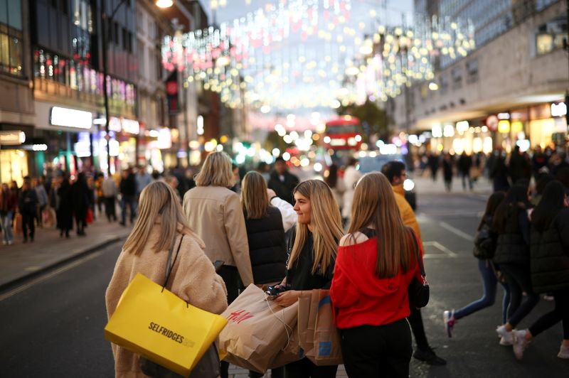 People walk along Oxford Street illuminated with Christmas lights in