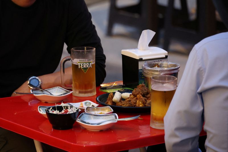 Businessmen enjoy fried chicken and beers at a pub in
