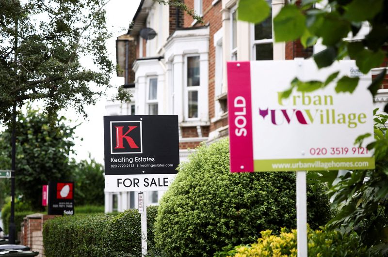 FILE PHOTO: Estate agent signs are seen outside a residential
