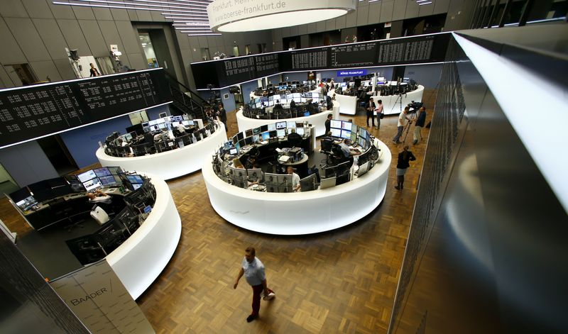 Traders work at their desks in front of the German