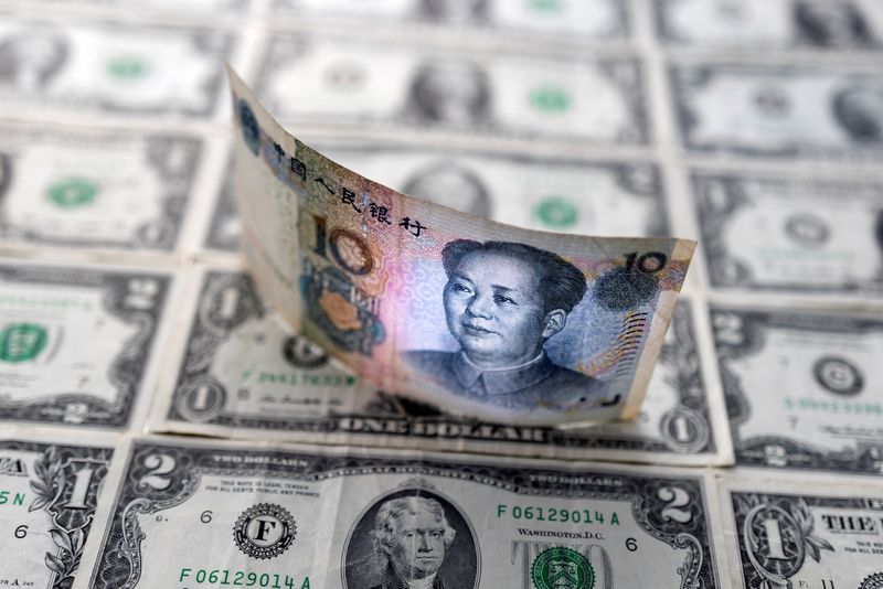 Illustration shows Chinese yuan banknote placed on U.S. Dollar banknotes