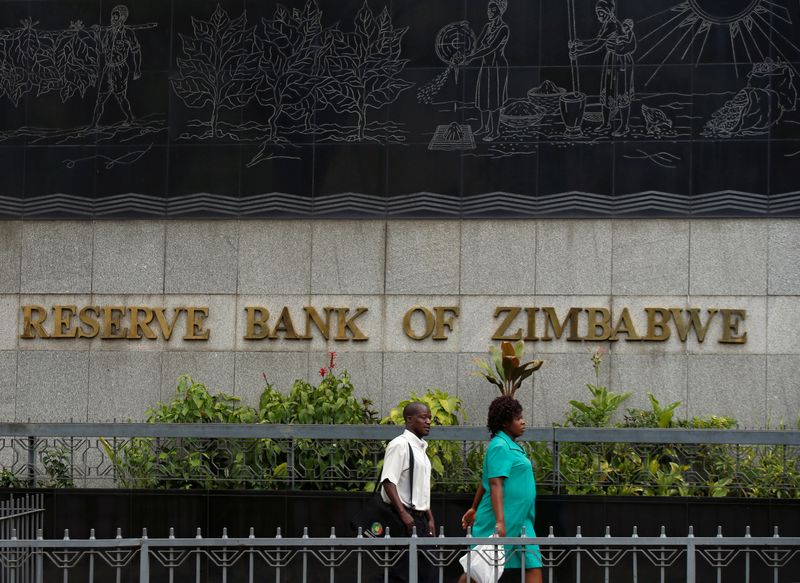 FILE PHOTO: People walk past the Reserve Bank of Zimbabwe