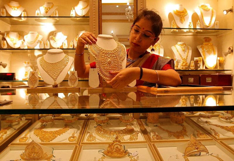FILE PHOTO: A saleswoman displays a gold necklace inside a