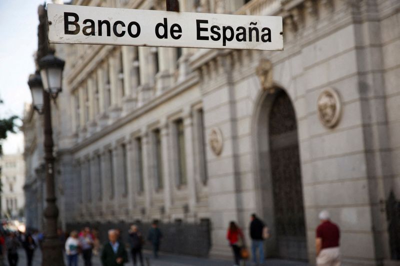 FILE PHOTO: People walk past the Bank of Spain in