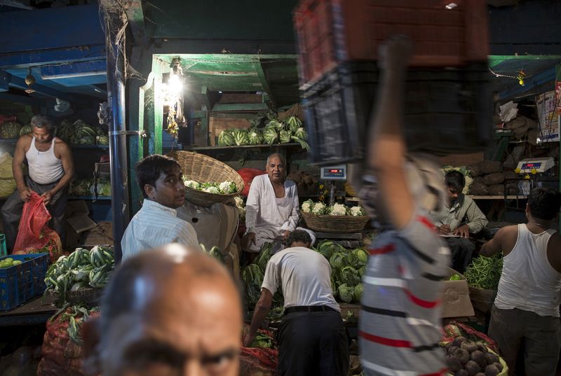 Vendors work at a wholesale vegetable and fruit market in