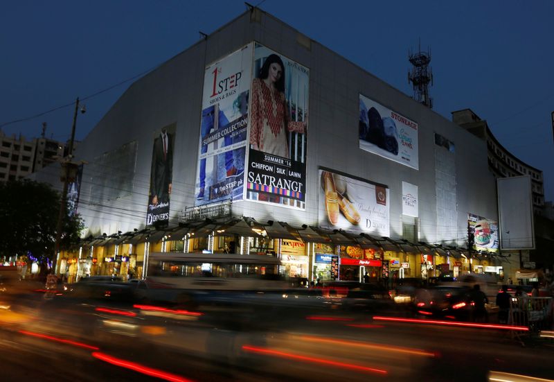 Cars move past Atrium Mall and Cinemas in Karachi