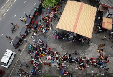 People wait in a queue to buy kerosene at a